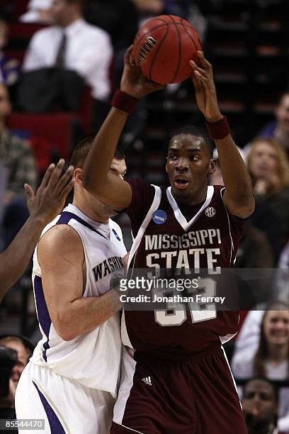 Jarvis Varnado of the Mississippi State Bulldogs looks to pass the ball as he is covered by Jon Brockman during the first round of the NCAA Division...