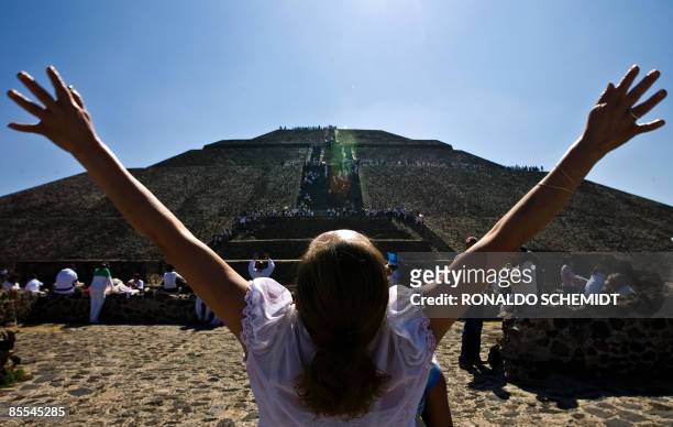 Woman gets energy from the sun in front of the Pyramid of the Sun in Teotihuacan, Mexico, during the celebrations for the Spring Equinox on March 21,...