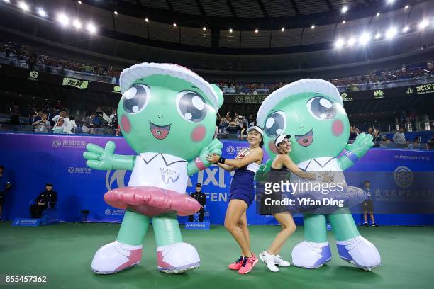 Yung-jan Chan of Chinese Taipei and Martina Hingis of Switzerland pose with the mascot after winning the he Ladies Doubles semi final match between...
