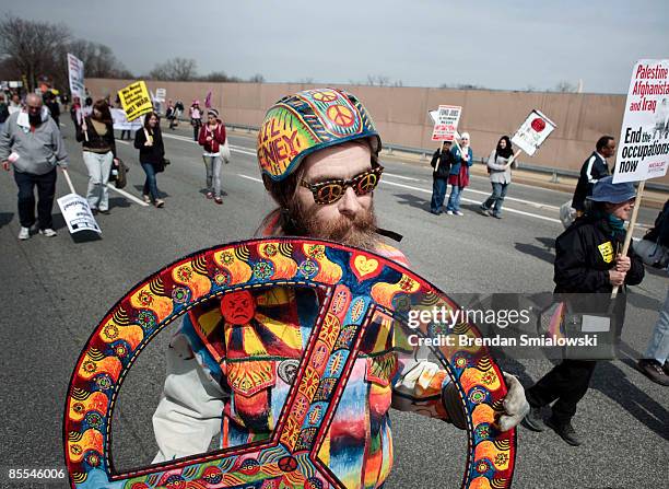 Man walks with a peace symbol dduring the "National March on the Pentagon" to protest the 6th anniversary of the US war in Iraq March 21, 2009 in...