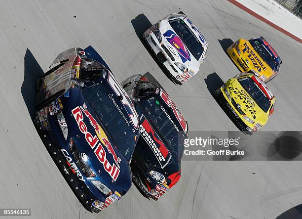 Scott Speed, driver of the Red Bull Toyota, races Robert Richardson, Jr., driver of the Mahindra Chevrolet, during the NASCAR Nationwide Series...