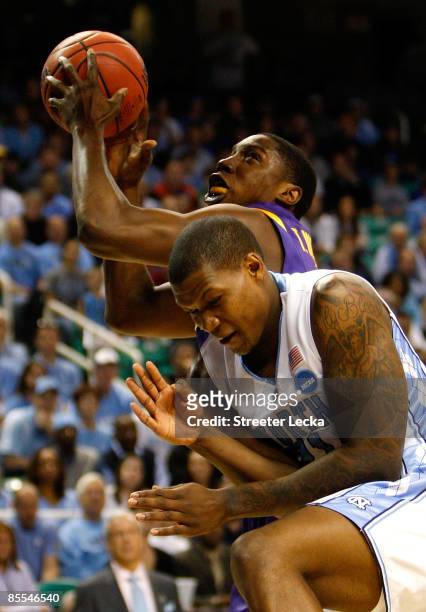 Tasmin Mitchell of the Louisiana State University Tigers drives against Deon Thompson of the North Carolina Tar Heels during the second round of the...
