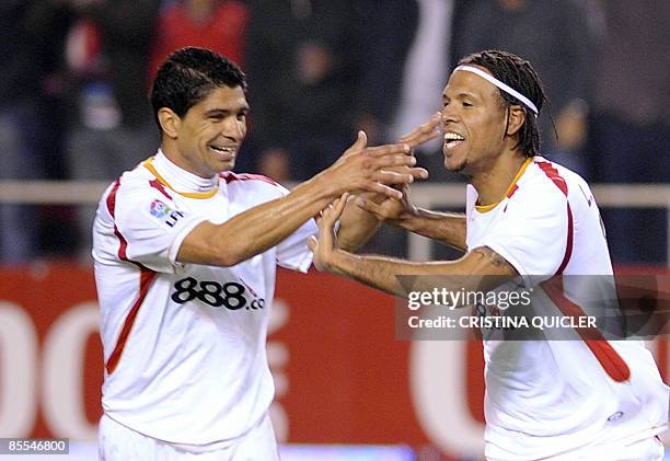 Sevilla's Luis Fabiano celebrates with teammate Renato Dirnei after scoring against Valladolid with their Spanish league football match at the...