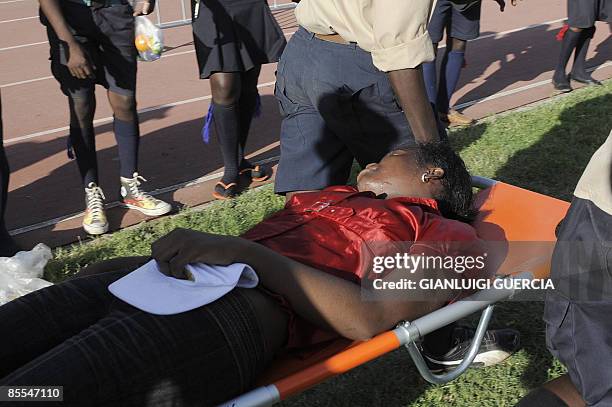 An unconscious girl receives medical attention by Angolan scouts on March 21, 2009 during a visit by Pope Benedict XVI in which he met with members...