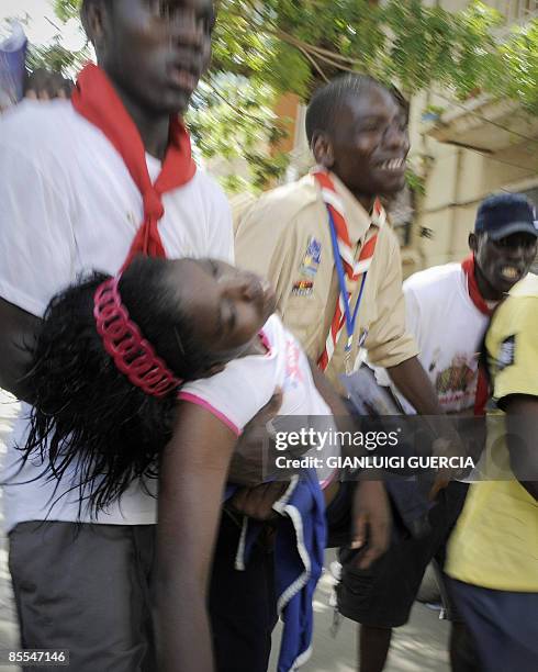 An unconscious girl receives medical attention by Angolan scouts on March 21, 2009 during a visit by Pope Benedict XVI in which he met with members...