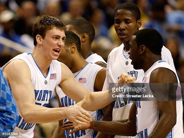 Ed Davis looks on as Tyler Hansbrough celebrates with Ty Lawson of the North Carolina Tar Heels after a basket against the Louisiana State University...