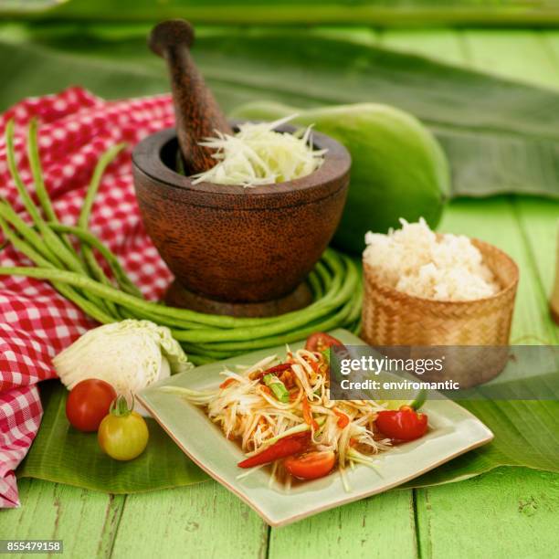 som tam tai, a popular and favourite thai food dish made of young sliced papaya, chili, tomatoes, palm sugar and dried shrimp with sticky rice. - papaya stock pictures, royalty-free photos & images