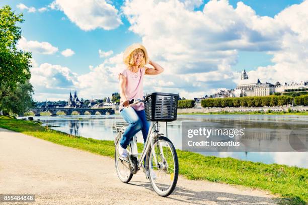 senior woman cycling loire valley, france - loire valley stock pictures, royalty-free photos & images