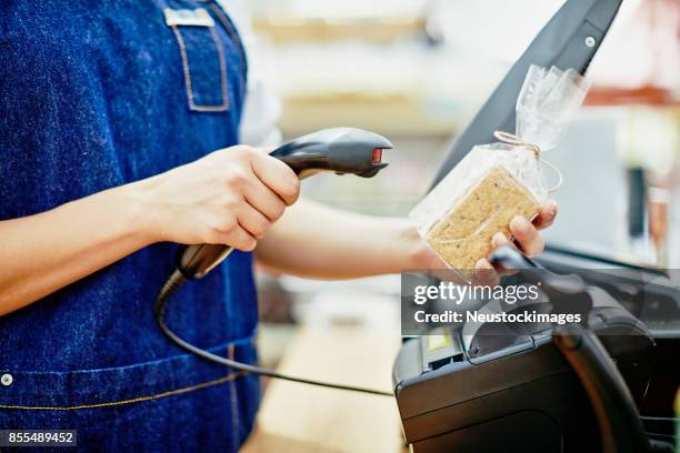 midsection of deli owner scanning barcode on food package - scan barcode stock pictures, royalty-free photos & images
