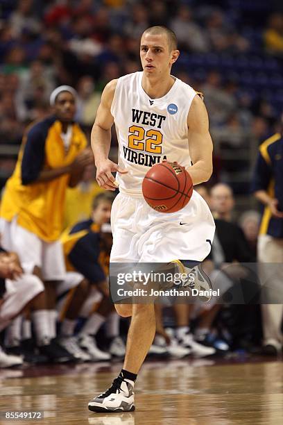 Alex Ruoff of the West Virginia Moutaineers brings the ball up court against the Dayton Flyers during the first round of the NCAA Division I Men's...