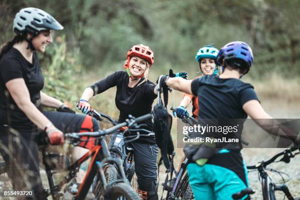 women mountain biking team - mountain biking stock pictures, royalty-free photos & images