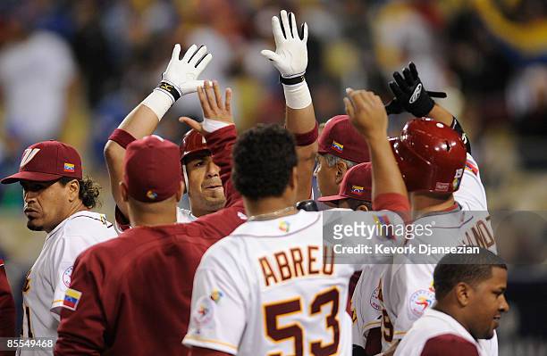 Carlos Guillen of Venezuela celebrates with teammates after hitting a home run in the seventh inning against Korea during the semifinal game of the...