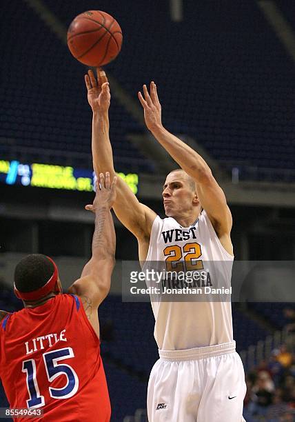 Alex Ruoff of the West Virginia Moutaineers attempts a shot against Charles Little of the Dayton Flyers during the first round of the NCAA Division I...