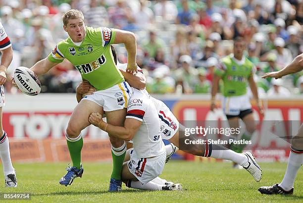 Glen Buttriss of the Raiders looks to off load the ball during the round two NRL match between the Canberra Raiders and the Sydney Roosters at...