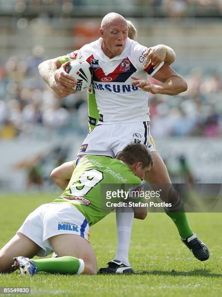 Craig Fitzgibbon of the Roosters is tackled during the round two NRL match between the Canberra Raiders and the Sydney Roosters at Canberra Stadium...