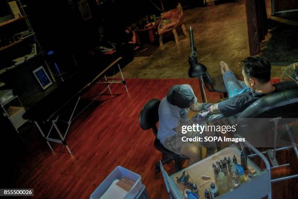 Gary Jones is seen while tattooing a client inside his shop. Gary Jones is one of the Kadazan talented tattoo artist from Borneo. He had almost 10...