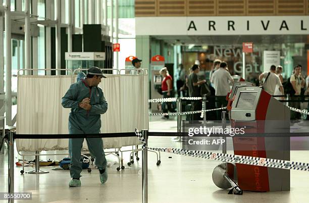 Member of the Australian police forensic personnel is seen at a crime scene at the Sydney Domestic Terminal 3 on March 22, 2009. Members of an...