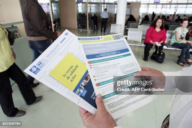 Une personne présente les brochures informant sur le nouveau RSA mises à la disposition des usagers dans un centre de la CAF à Paris le 04 juin 2009....
