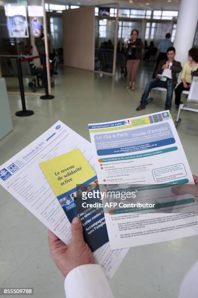 Une personne présente les brochures informant sur le nouveau RSA mises à la disposition des usagers dans un centre de la CAF à Paris le 04 juin 2009....