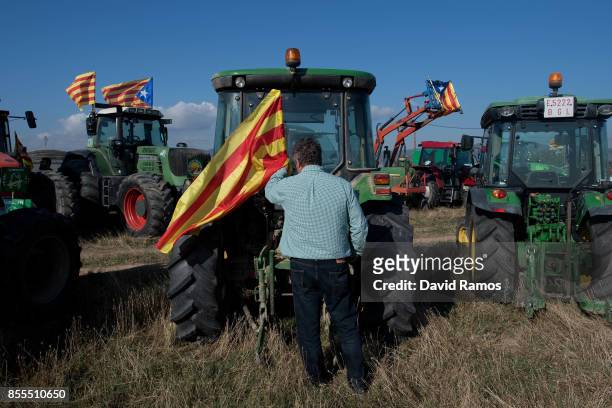 Farmer attaches a Catalan flag on his tractor before marching during a farmers union protest supporting the Yes vote on September 29, 2017 in...