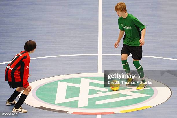 Players of SV Nettelnburg-Allermoehe and BV 04 Duesseldorf tackle for the ball during the DFB Futsal Cup at the Rhein-Ruhr-Sporthalle on March 23,...