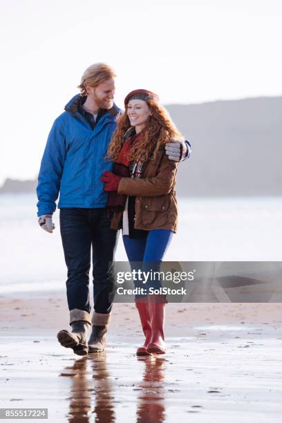 couple on the beach during winter - romantic couple walking winter beach stock pictures, royalty-free photos & images