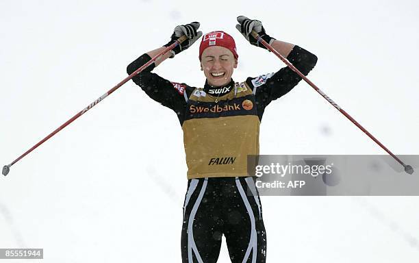 Poland's Justyna Kowalczyk celebrates after crossing the finish line of the women's 10 km pursuit during the Cross Country skiing world cup in Falun...