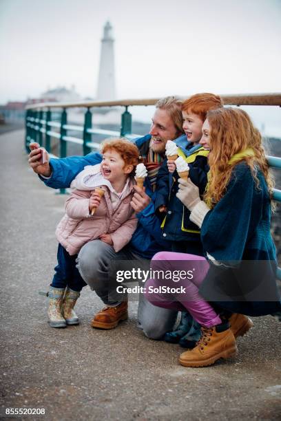 familie, die eine selfie mit ihren ice – sahne kegel an der küste - eisstockschießen stock-fotos und bilder