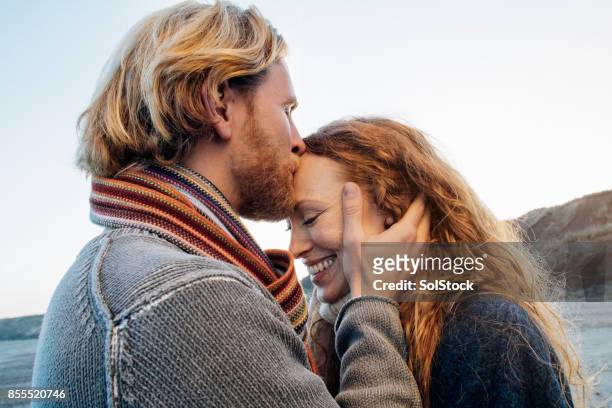 ビーチでロマンチックな日 - young couple kiss ストックフォトと画像