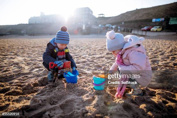 Siblings Playing in the Sand on a Winter's Day