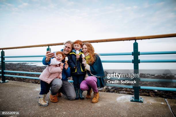 redhead family taking a selfie at the coast - winters day stock pictures, royalty-free photos & images