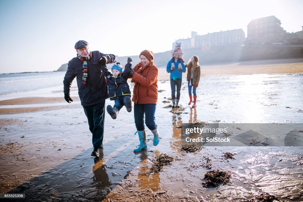 Multi- Generation Family Walking Along the Beach