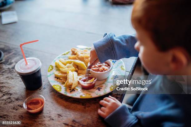 little boy enjoying fish and chips at a beach cafe - baked beans stock pictures, royalty-free photos & images