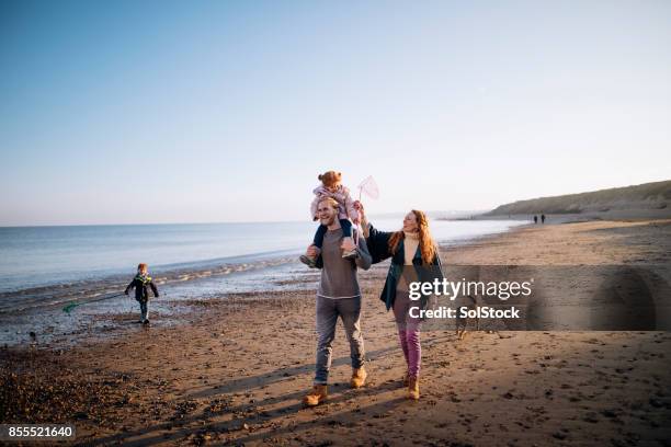 familie am strand im winter - family walking stock-fotos und bilder