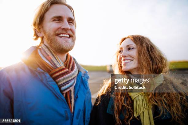couple in love waking along the coast - tynemouth beach stock pictures, royalty-free photos & images