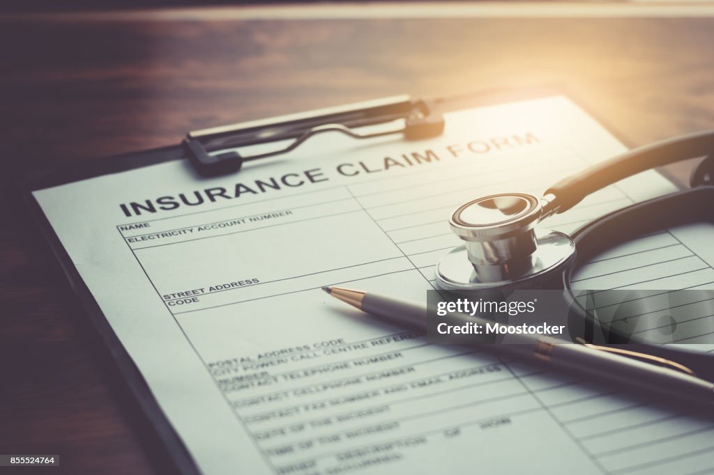 Health insurance claim form with stethoscope on wood table selective focus