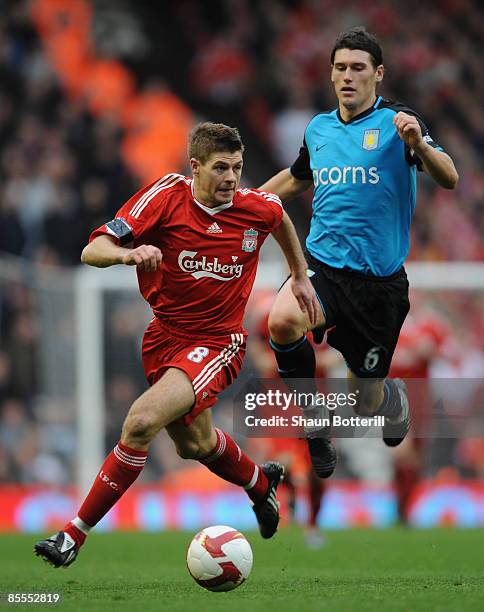 Steven Gerrard of Liverpool goes past Gareth Barry of Aston Villa during the Barclays Premier League match between Liverpool and Aston Villa at...