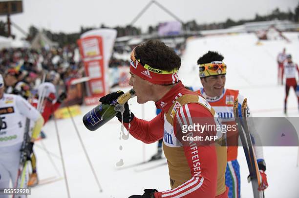 Switzerland's Dario Cologna drinks champagne after the victory in the men's 15 km pursuit during the Cross Country skiing world cup in Falun, Sweden,...