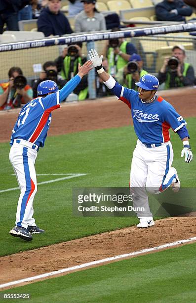 Shin-Soo Choo of Korea celebrates with teammates after hitting a three-run homerun in the first inning of the semifinal game of the 2009 World...