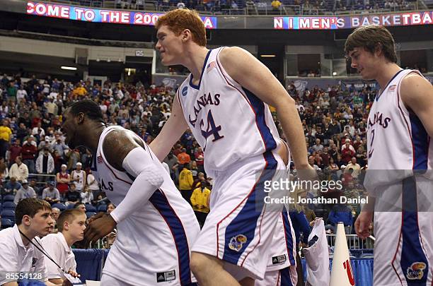 Sherron Collins, Matt Kleinmann and Conner Teahan of the Kansas Jayhawks celebrate as they walk off the court following their 60-43 win against the...