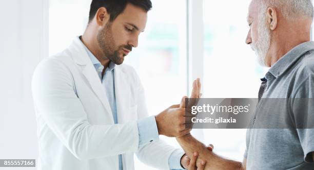 examen del dolor de muñeca. - muñeca articulación fotografías e imágenes de stock