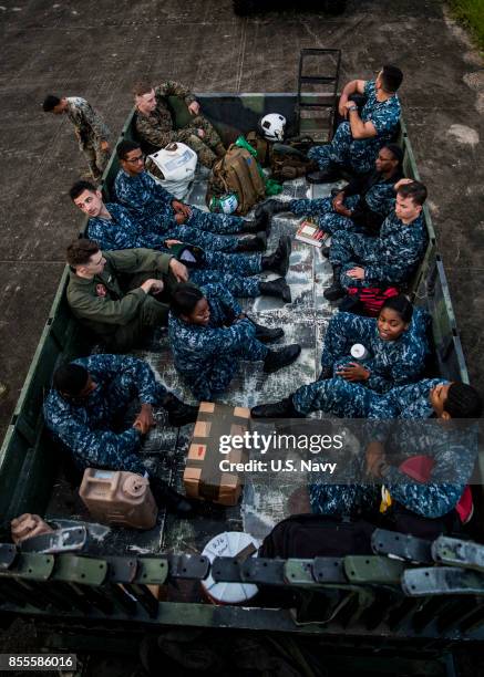 In this U.S. Navy handout, U.S. Marines and Sailors attached to the 26th Marine Expeditionary Unit wait in a truck at Jose Aponte de la Torre Airport...