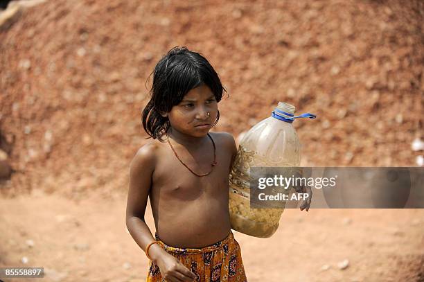 Bangladeshi girl carries a plastic vessel as she arrives to collect water from a tanker in Dhaka on March 21, 2009 in an area which has been...