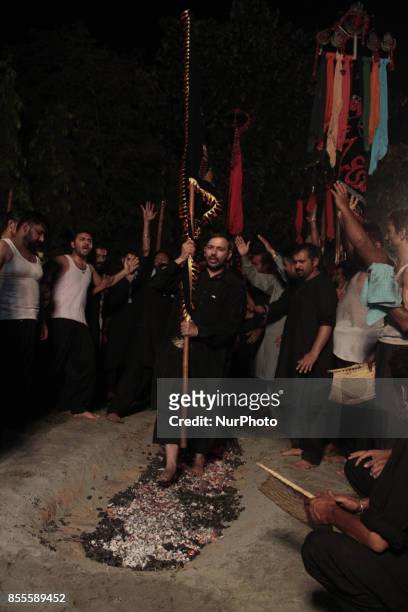 Shiite Muslims walk over burning coal during religious procession during the month of Muharram-ul-Haram which is the first month of the Islamic...