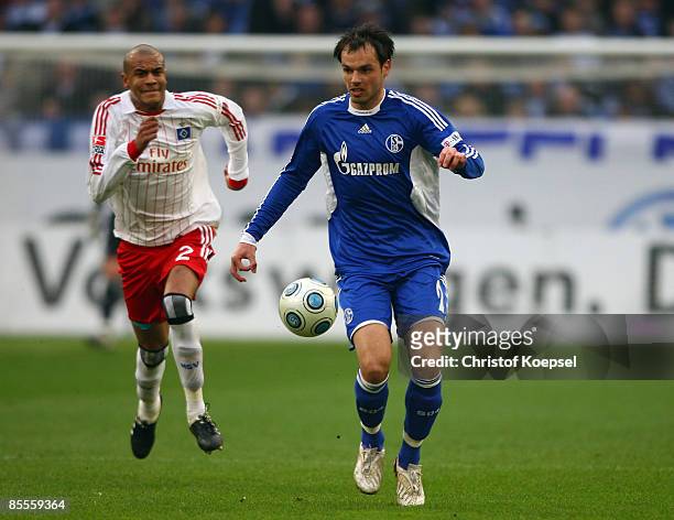 Heiko Westermann of Schalke runs with the ball and Alex Silva of Hamburg follows him during the Bundesliga match between Schalke 04 and Hamburger SV...