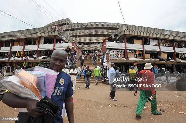 Street vendor tries to sell shirts on March 16, 2009 at the Yaounde main market. AFP PHOTO / ISSOUF SANOGO