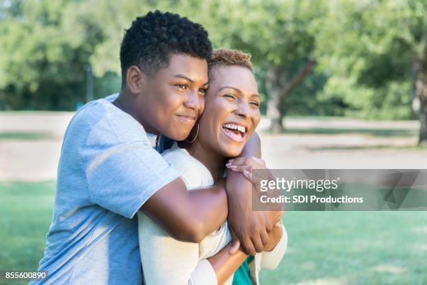 hijo adolescente amante le da a su madre un abrazo - handsome black boy fotografías e imágenes de stock