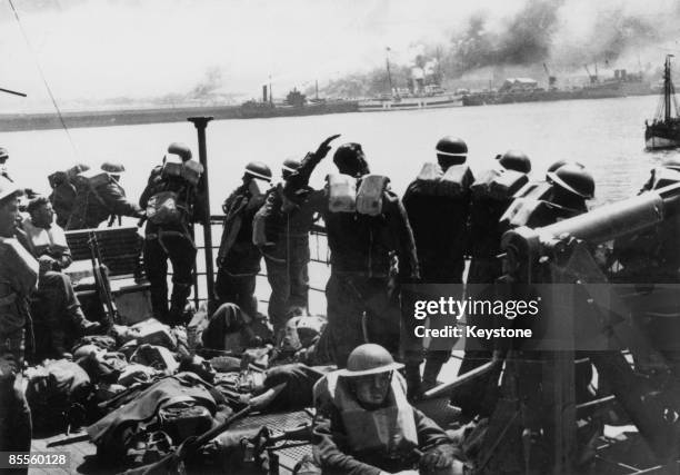 British troops look back at the French coast from the deck of a steamer which is taking them back to England after the evacuation of Dunkirk, June...