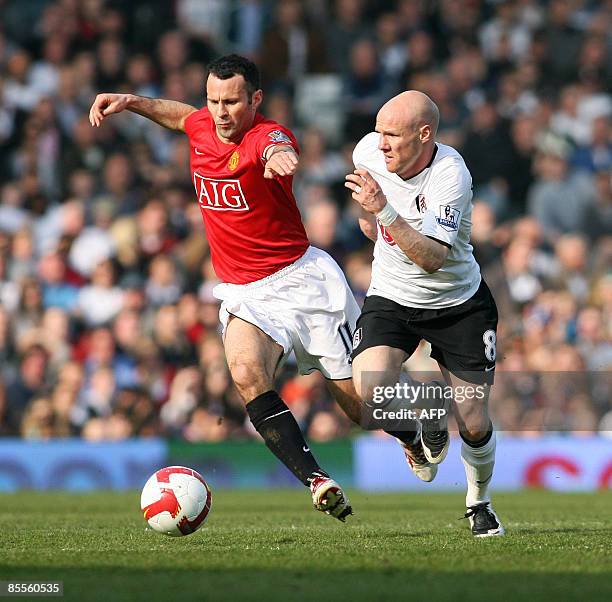 Manchester United's Welsh player Ryan Giggs vies with Fulham's English striker Andy Johnson during the Premier League football match between Fulham...