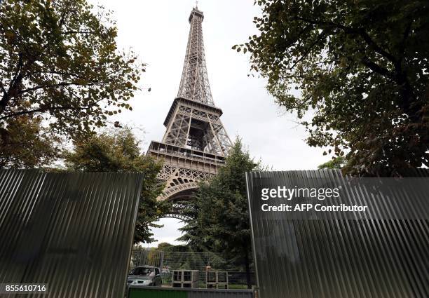 Picture taken on September 29, 2017 shows metal gates set up for the construction of bulletproof glass walls set to go up around the Eiffel Tower, in...